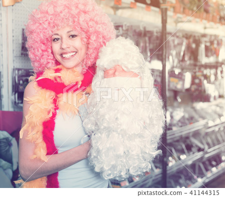 Woman preparing to fest and choosing clown wig Woman preparing to fest and choosing clown wig 41144315