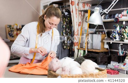Smiling woman professional working with material at atelier 41144320