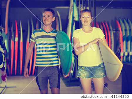 Young couple of surfers holding new surfboard Young couple of surfers holding new surfboard 41144390