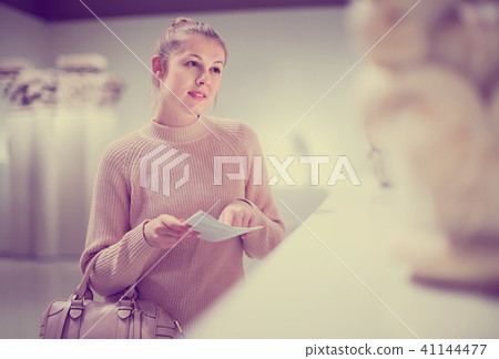 Girl looking with interest at ancient sculptures in museum, using guidebook Girl looking with interest at ancient sculptures in museum, using guidebook 41144477