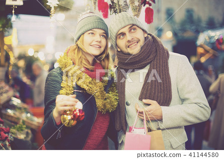 Girl with boy choosing decorations at Christmas market Girl with boy choosing decorations at Christmas market 41144580