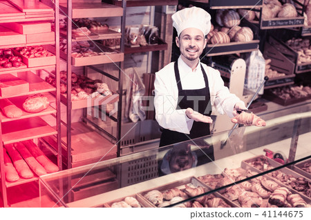 Man baker showing warm tasty croissant 41144675