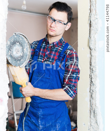 Young male workerusing professional angle grinder 41144798