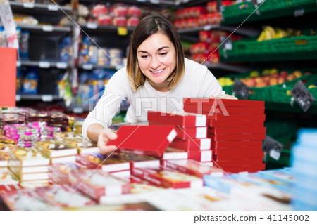 concentrated girl customer looking for tasty sweets in supermarket concentrated girl customer looking for tasty sweets in supermarket 41145002