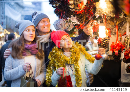 married couple with a teenage daughter at Christmas market 41145129