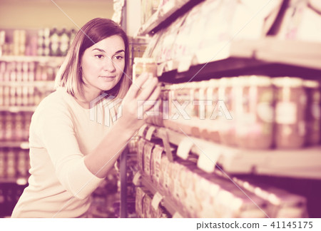 attractive girl customer looking for tasty baby food 41145175