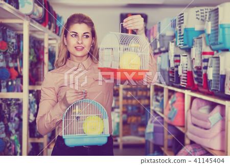 Woman choosing pets cage 41145404