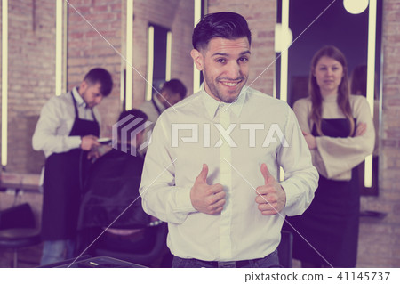 Satisfied man approving result of hairdresser work Satisfied man approving result of hairdresser work 41145737