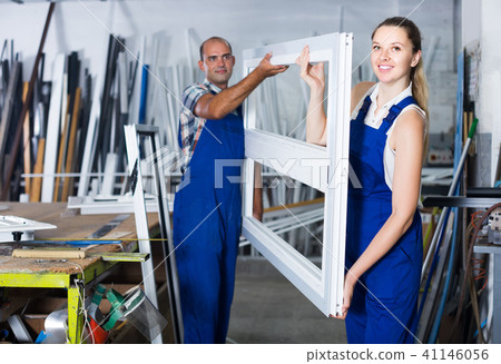 Two professional workers working in assembly shop of plastic windows Two professional workers working in assembly shop of plastic windows 41146056