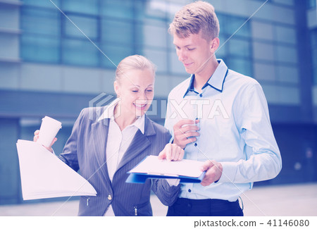 Young businessman and his colleague are reading documents Young businessman and his colleague are reading documents 41146080