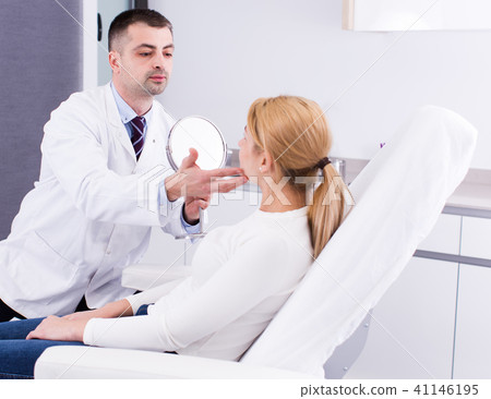 Cosmetologist examining female face Cosmetologist examining female face 41146195