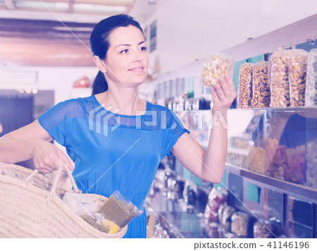 female customer choosing natural dried berries sold by weight in eco market female customer choosing natural dried berries sold by weight in eco market 41146196