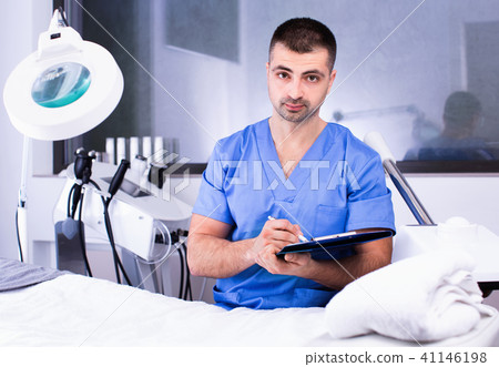 Portrait of professional cosmetician working with papers in clinic of esthetic cosmetology Portrait of professional cosmetician working with papers in clinic of esthetic cosmetology 41146198