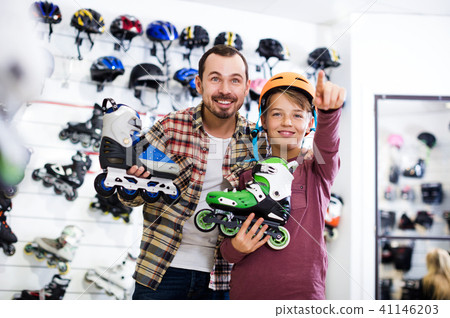 Seller assisting boy in choosing roller-skates 41146203