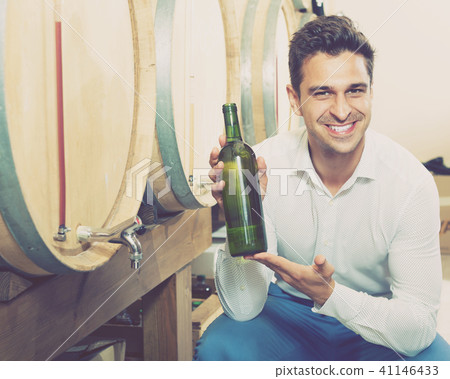 Portrait of man customer having bottle of wine in shop Portrait of man customer having bottle of wine in shop 41146433