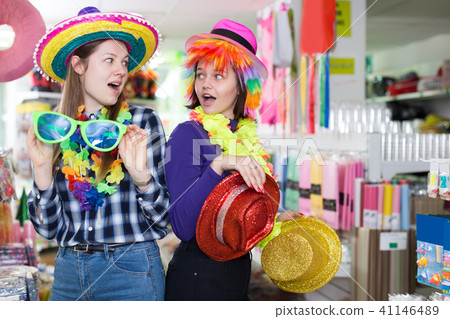 cheerful girls together looking for festival hats 41146489