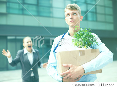 Manager in suit is standing upset near office 41146722