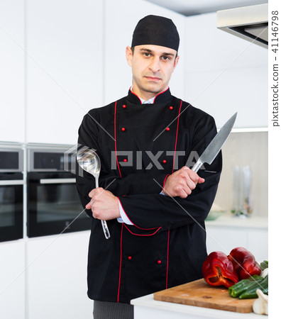Portrait of man cook who is standing with devices on his work place in the kitchen Portrait of man cook who is standing with devices on his work place in the kitchen 41146798