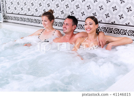 Company of three people relaxing enjoying jacuzzi Company of three people relaxing enjoying jacuzzi 41146815