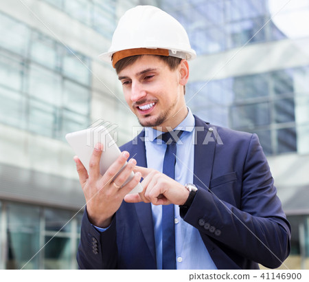 Smiling man working outdoors at modern touchpad Smiling man working outdoors at modern touchpad 41146900