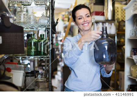 Portrait of positive woman choosing fragile glass item 41146991