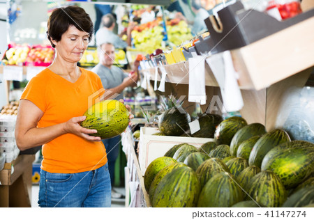 Woman choosing melon in store 41147274