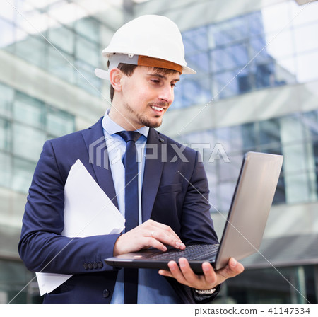 Male builder talking about work at the laptop 41147334