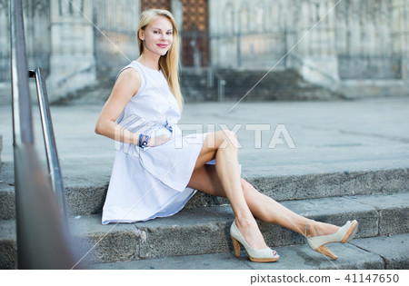 Adult female sitting on stone steps 41147650