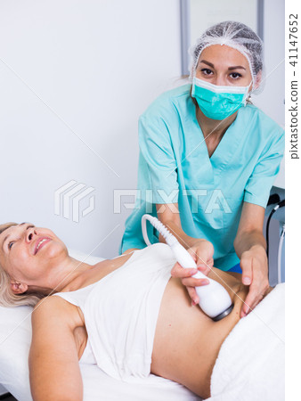 Professional cosmetician performing cryolipolyse Professional cosmetician performing cryolipolyse 41147652