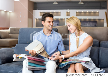 Couple are choosing of colors for new sofa Couple are choosing of colors for new sofa 41147653