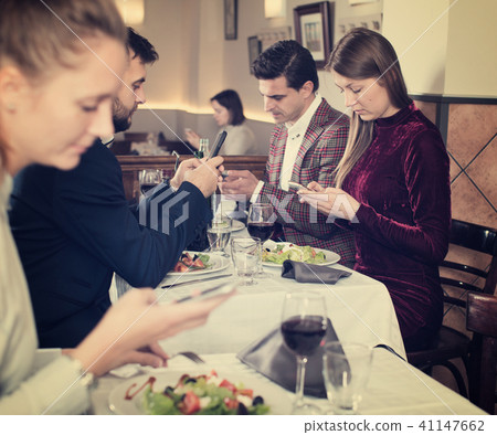 Modern young people with phone at restaurant 41147662