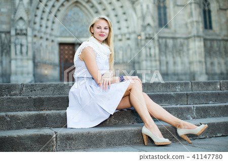 smiling woman sitting in the city center in shawl smiling woman sitting in the city center in shawl 41147780