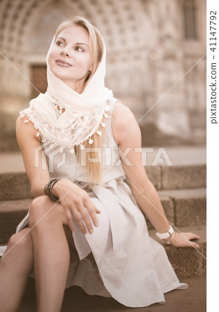 smiling woman sitting in the city center in shawl 41147792