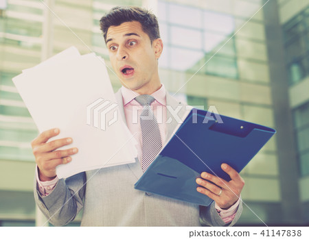 Shocked businessman reading papers 41147838