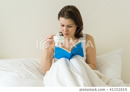 Mature woman in bed reading book 41152819