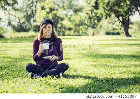 Beautiful woman holding coffee cup and smiling Beautiful woman holding coffee cup and smiling 41153097