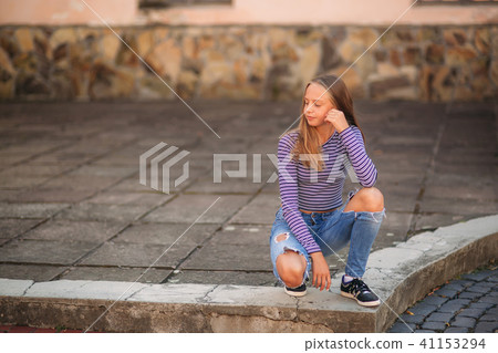 young teenage poses for photo. blonde girl in jeans and blouse young teenage poses for photo. blonde girl in jeans and blouse 41153294