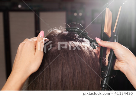 hairdresser clipping hair of a model hairdresser clipping hair of a model 41154450