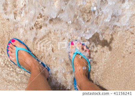 Woman legs stands in sea water on a tropic beach 41156241