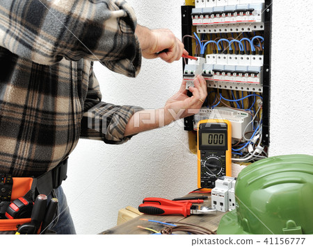 Electrician technician at work on a electric panel 41156777