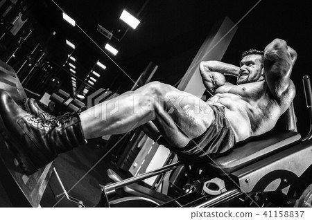 Handsome model young man training legs in gym Handsome model young man training legs in gym 41158837