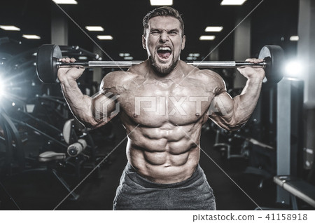 Handsome model young man training legs in gym 41158918