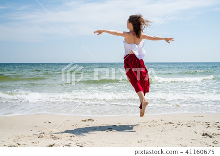 Beautiful girl in red dress by the sea. Beautiful girl in red dress by the sea. 41160675