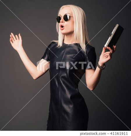 stylish woman in black dress with small silver bag 41161911