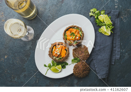 Fresh opened sea urchins. Caviar of sea urchins with onion, cilantro and lemon inside of shell of 41162607
