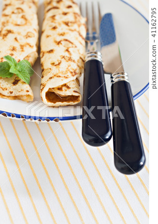 thin pancakes rolled crepes mint on a plate with  41162795