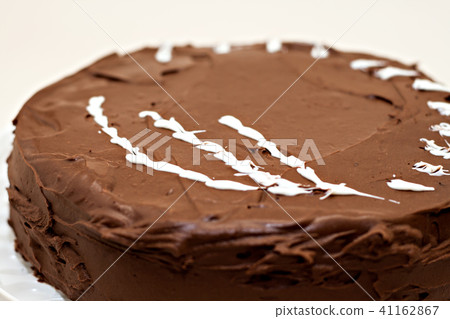 Round chocolate cake sprinkled with white  41162867