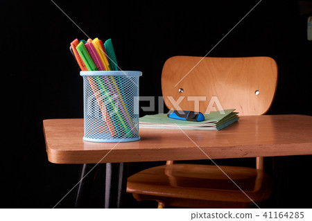 Colored Pens in a blue metal basket on desk  41164285