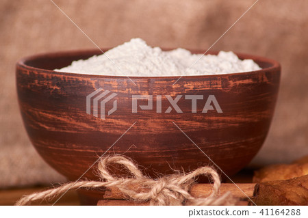 A bowl with flour and apricot cake  41164288