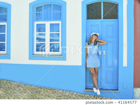 A girl in a blue dress near the Portuguese house in summer 41164577